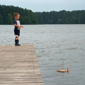 a boy and his toy sailboat on a Tennessee lake