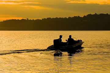 fishermen in a motorboat on a Pennsylvania lake at sunrise